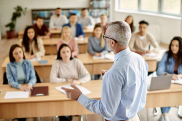 rear-view-of-mature-teacher-talking-to-his-student-during-lecture-at-university-classroom-3
